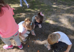 4 latki sprzątają teren wokół budynku przedszkola